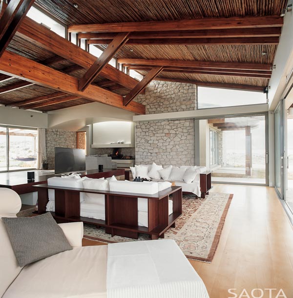 The interior of the house is characterized by smooth and rough stone surfaces as well as a natural wooden ceiling.