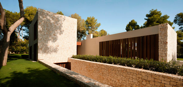 The exterior design of the house is characterized by the combination of rough stone walls and modern architectural shapes.