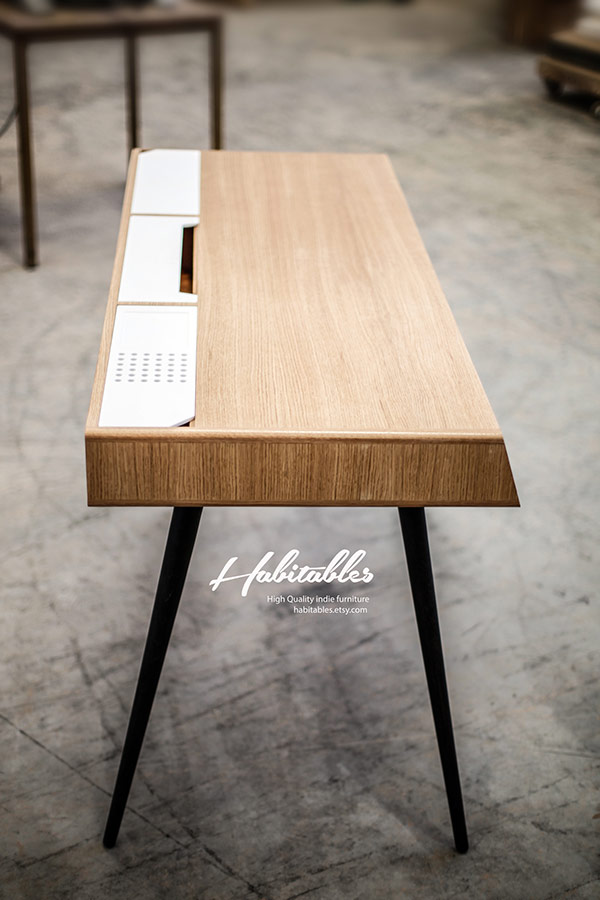 On the top of the desk are 3 covered compartments that are inserted into the table top.