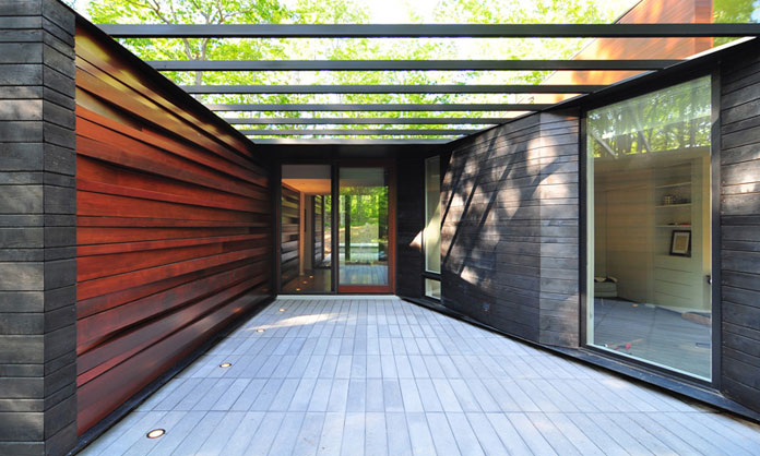 The entrance of the house was enhanced by a wall of wood slats, which have been stacked at slight angles. The entrance of the house was enhanced by a wall of wood slats, which have been stacked at slight angles.