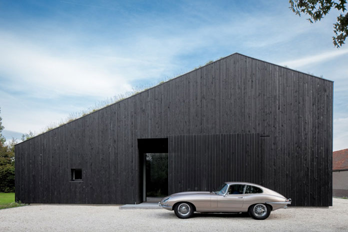 Minimalist architecture with black, wood-clad walls.